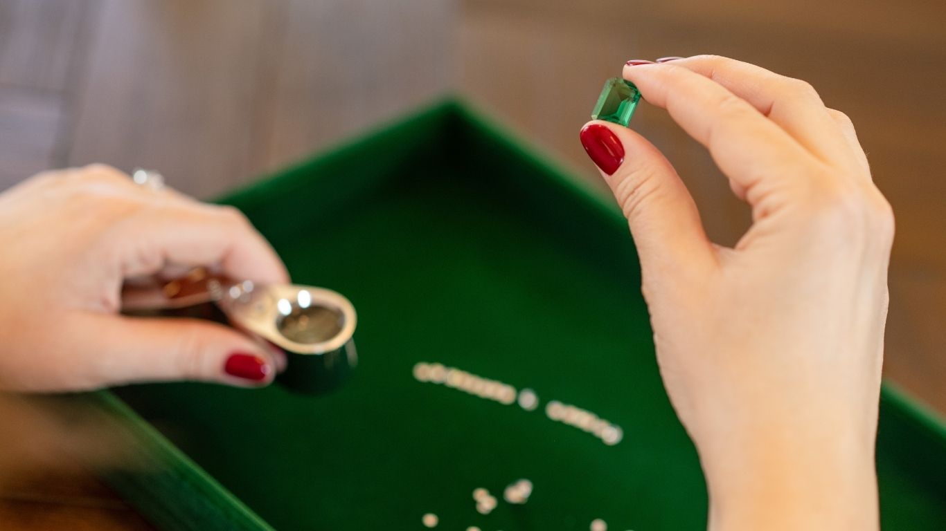 Sarah holding an emerald – expertise in natural gemstones and traceable diamonds