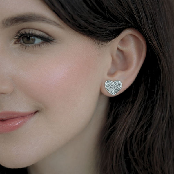 Model wearing Esmeé pavé heart diamond earrings in 18k white gold with traceable natural diamonds.