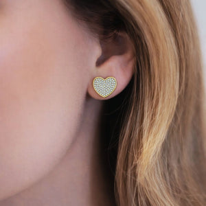 Model wearing Esmeé pavé heart diamond earrings in 18k yellow gold with traceable natural diamonds.