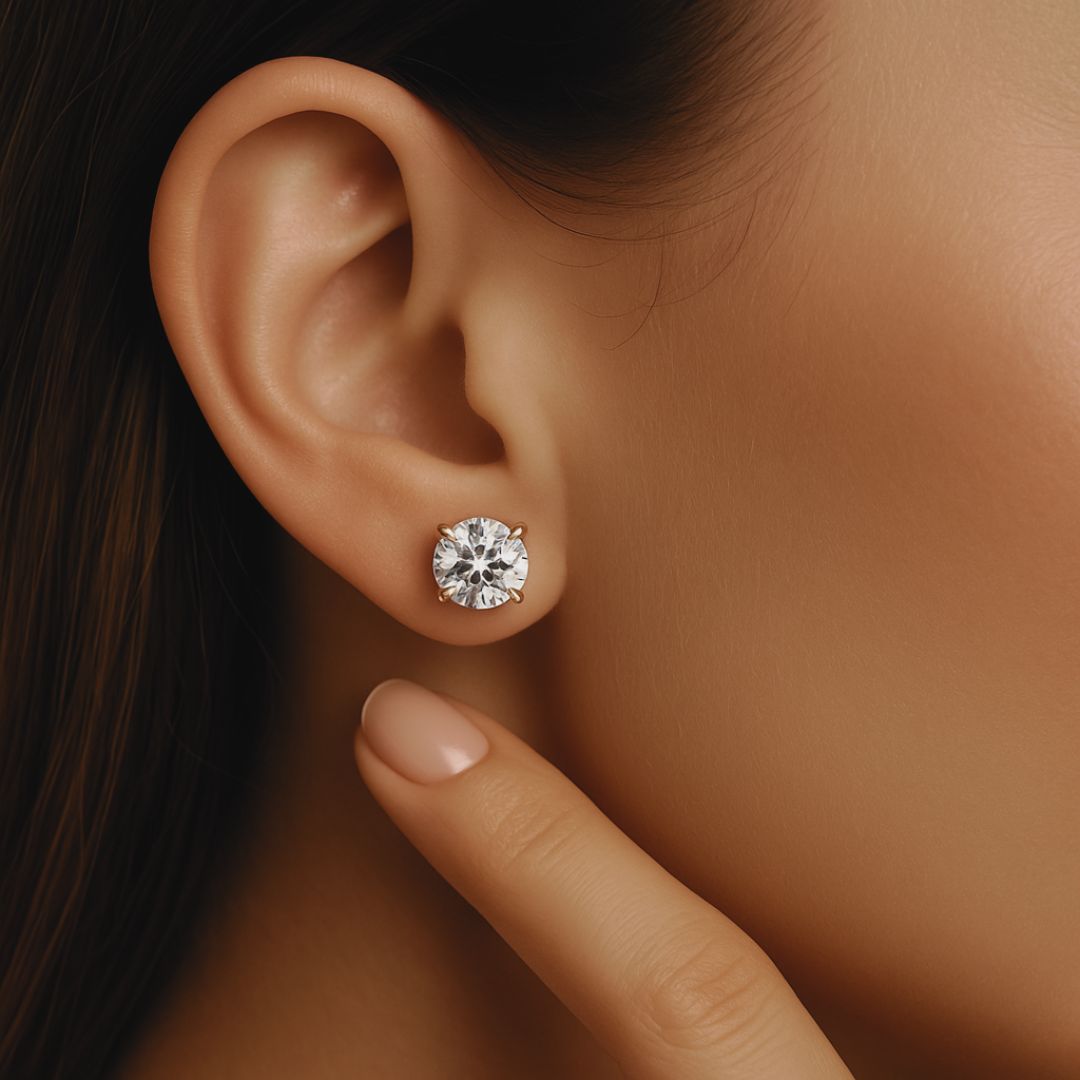 Close-up of a woman wearing elegant natural diamond stud earrings in white gold by CAREDIAMONDS – timeless sparkle and refined craftsmanship.