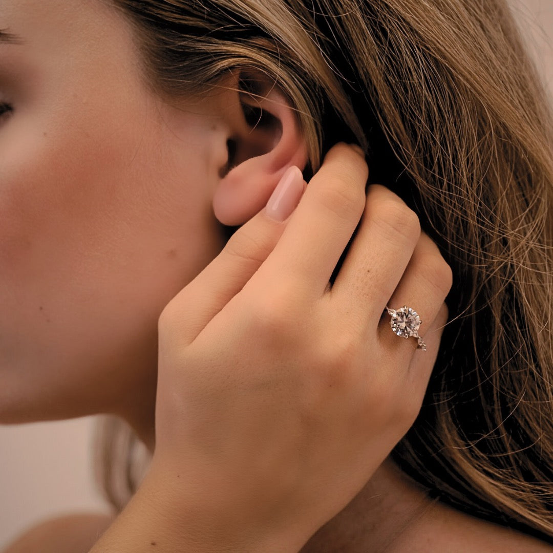 Woman wearing an elegant solitaire engagement ring with a traceable natural diamond by CAREDIAMONDS – captured in soft, natural light.