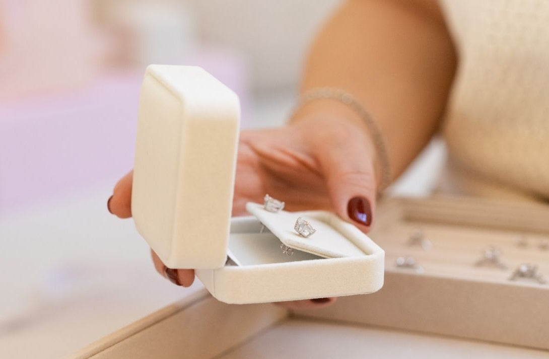 Diamond stud earrings in jewelry box held by Sarah – traceable natural diamonds